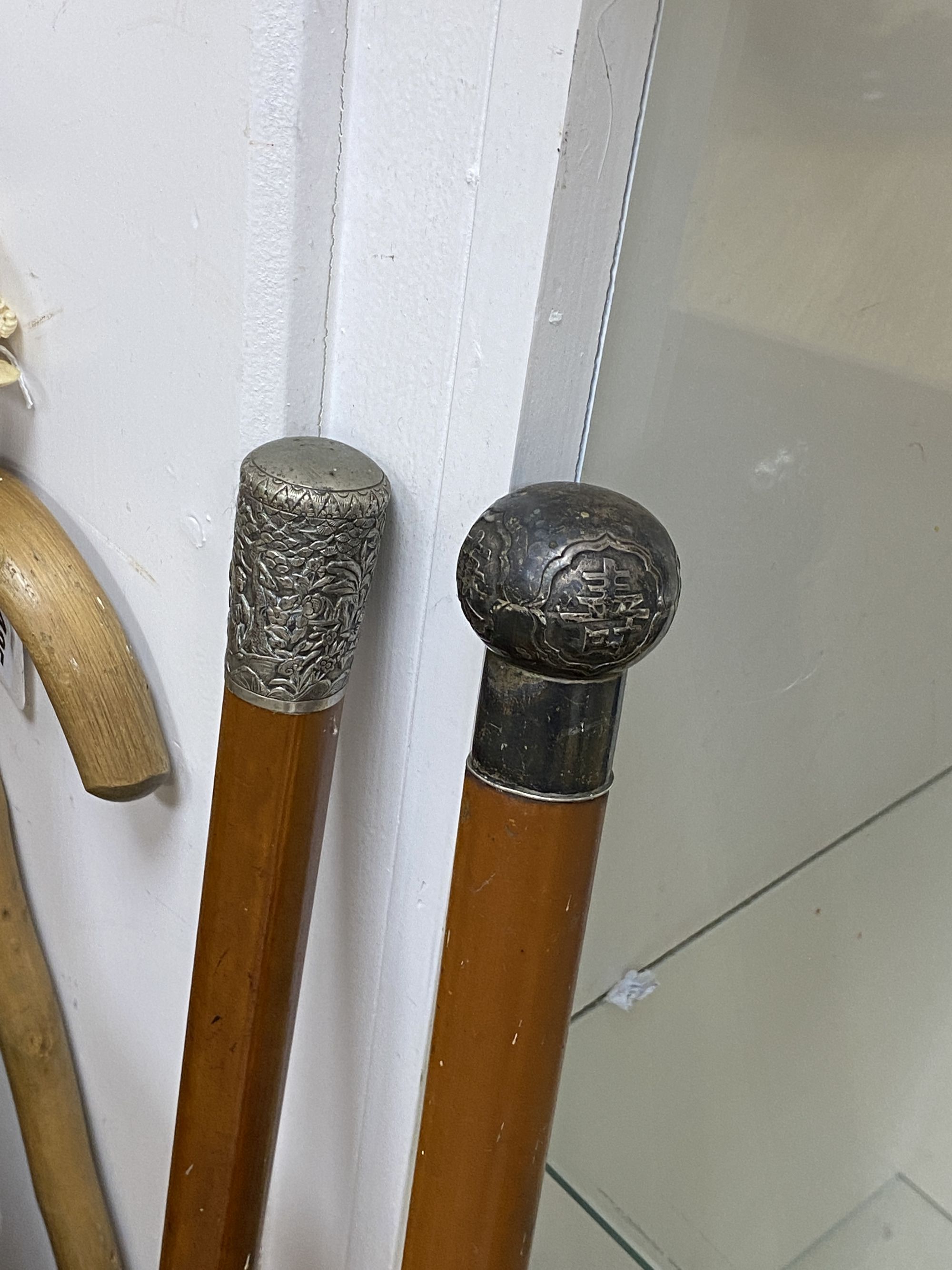 A collection of walking sticks, including ivory handles